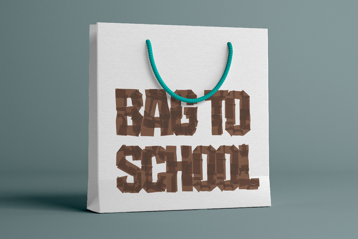 Brown Tape Font On A Paper Carrier Bag White paper carrier bag with a two-word phrase in the Brown Tape Font.